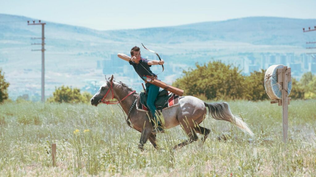 A horseback archer practicing in a green field