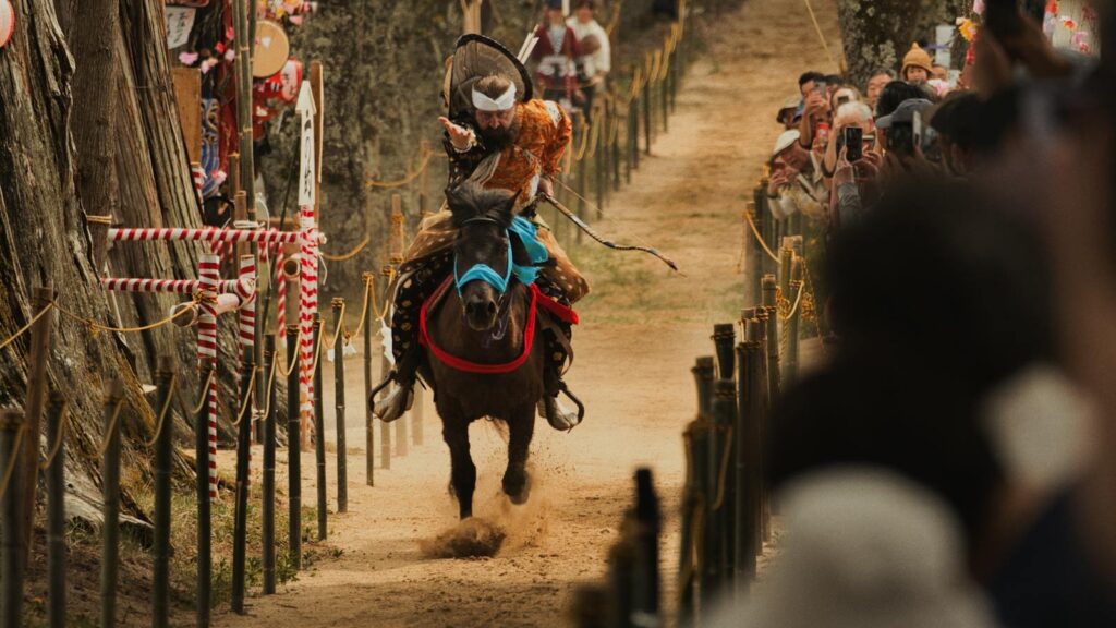 archer on horseback shooting an arrow during a festival.