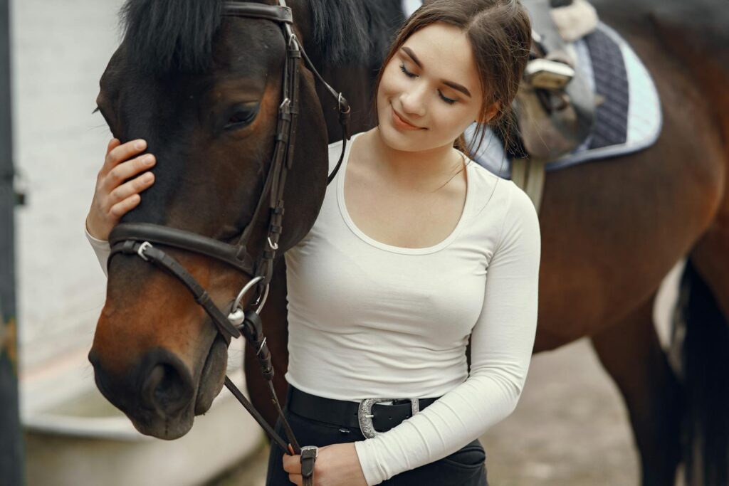 Young woman tenderly petting a horse