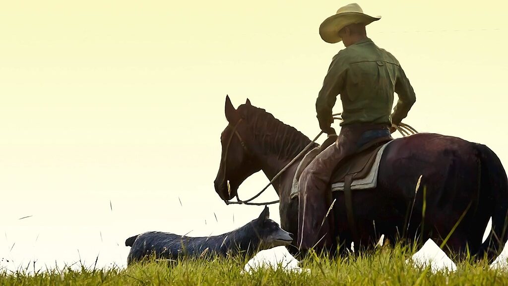A cowboy on horseback,accompained by a dog