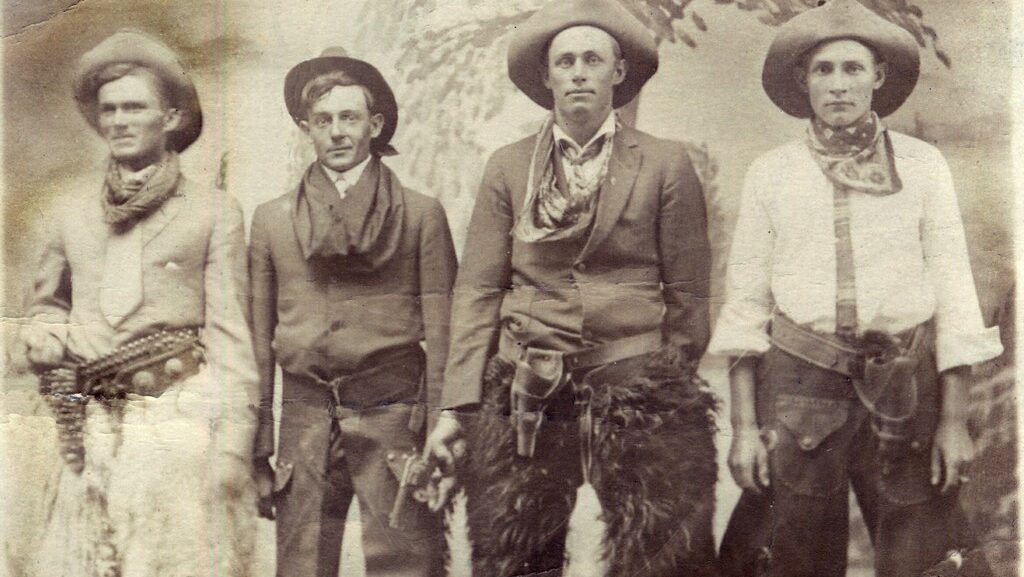 4 cowboys are standing