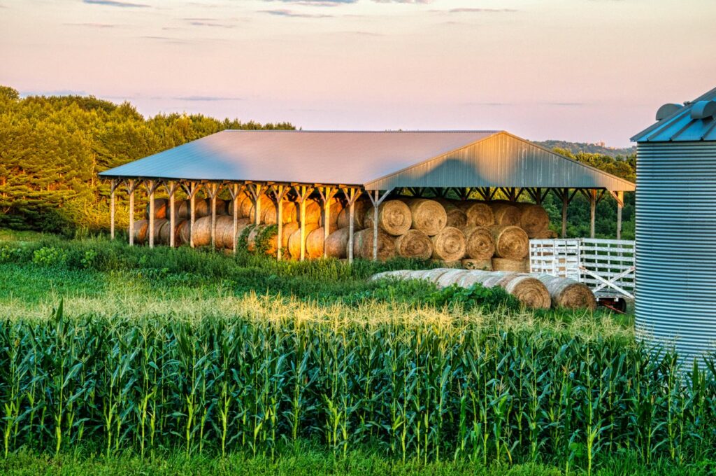 Stunning rural farm scene in Minnesota with hay bales at sunset.