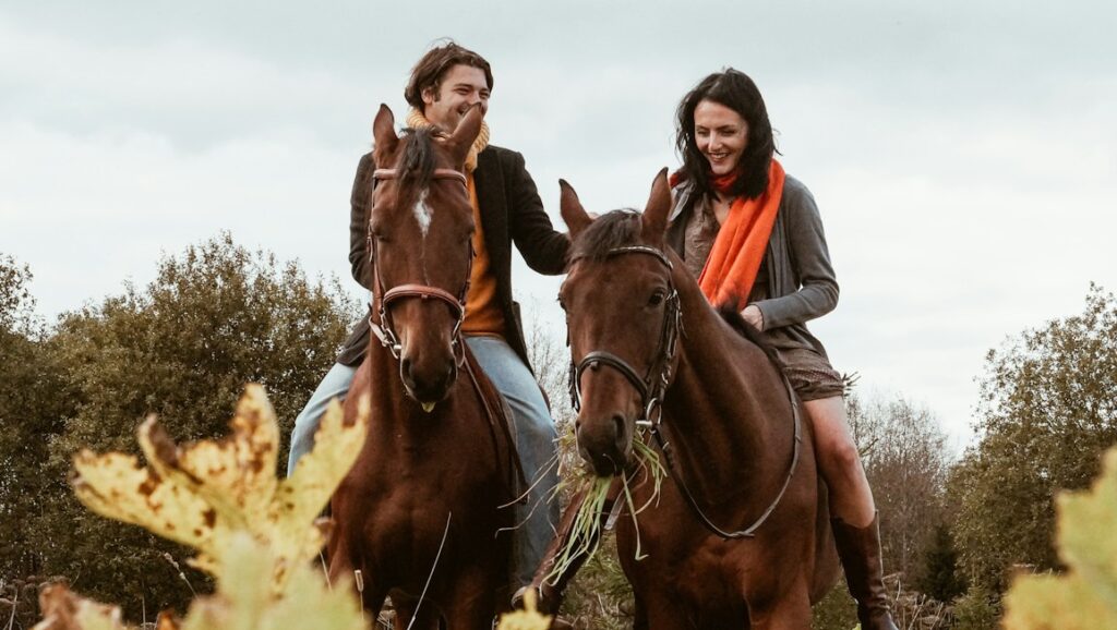 woman in black jacket riding brown horse during daytime