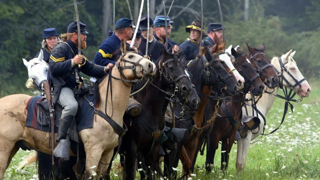 men riding horses on green grass field during daytime