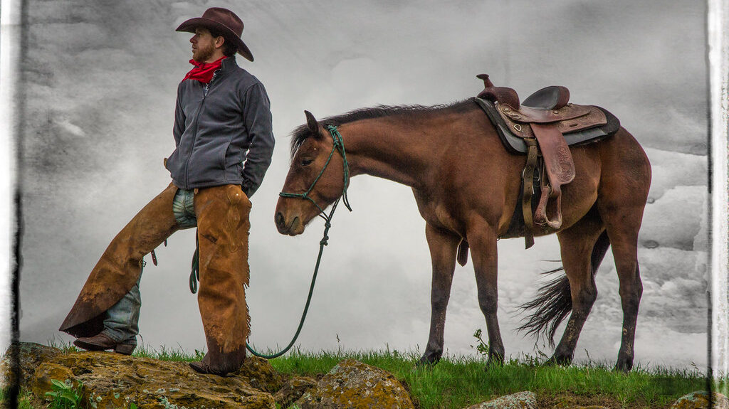 A ranch hand with his partner horse standing and seeing the other side.