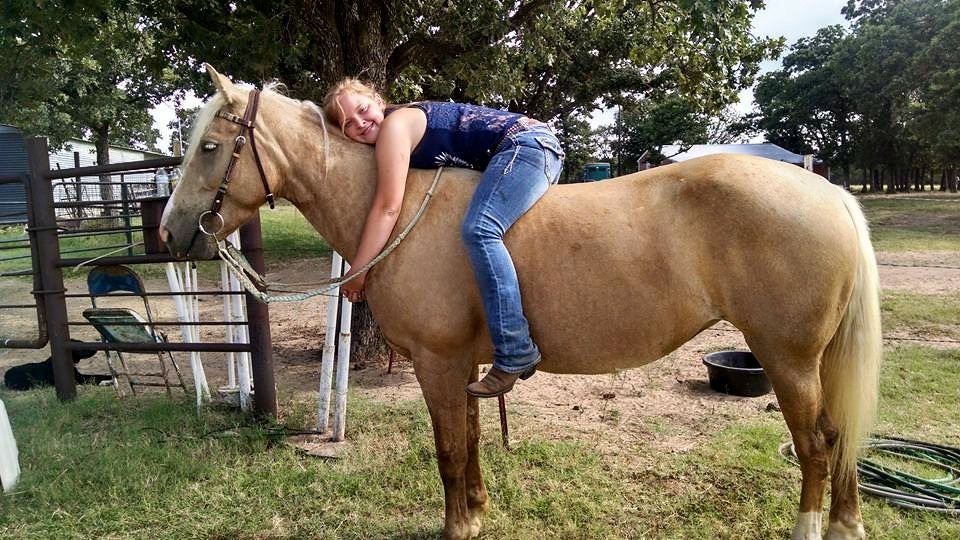 Girl hugging horse