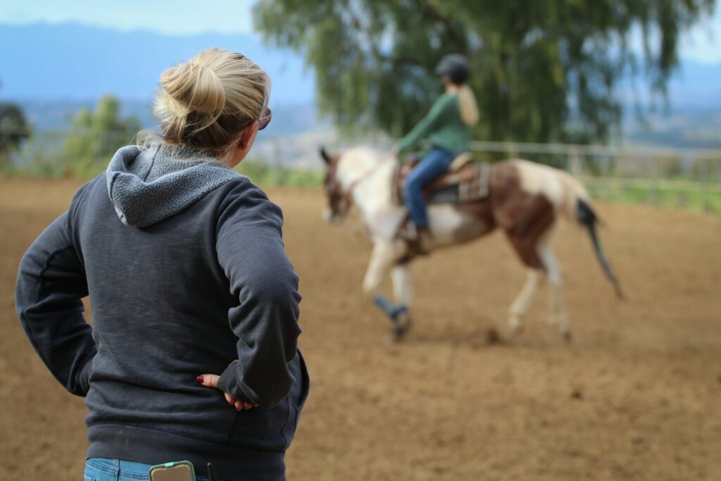 Woman watching man riding horse