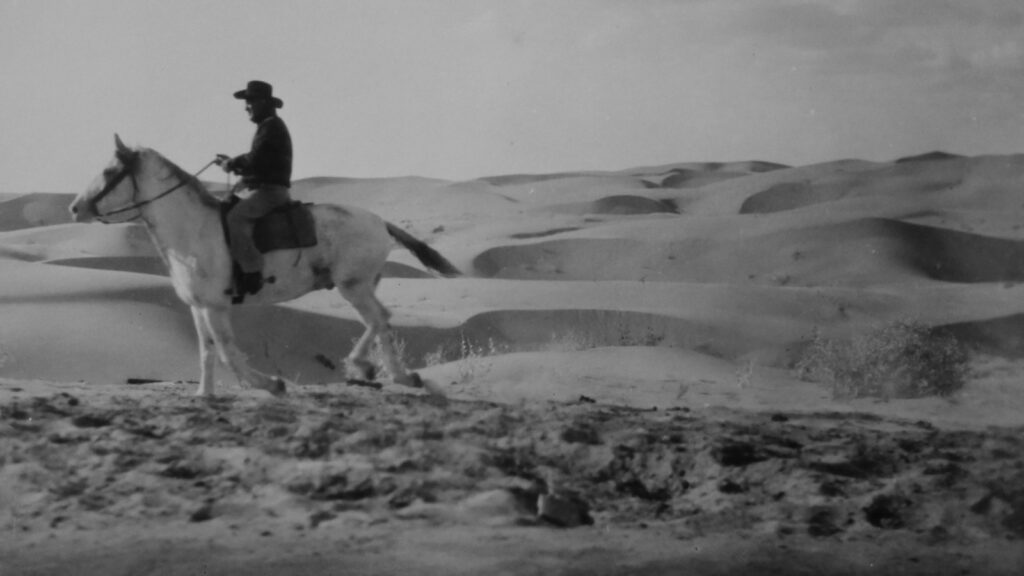 man riding horse on desert