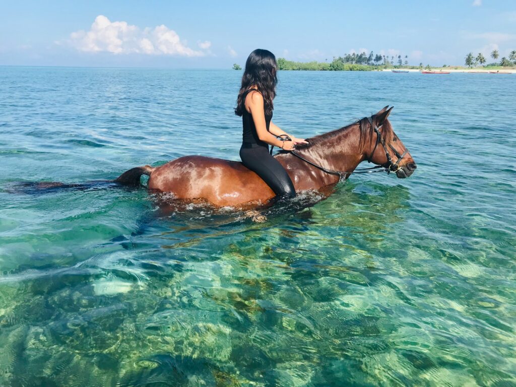 Woman is riding a horse in the water