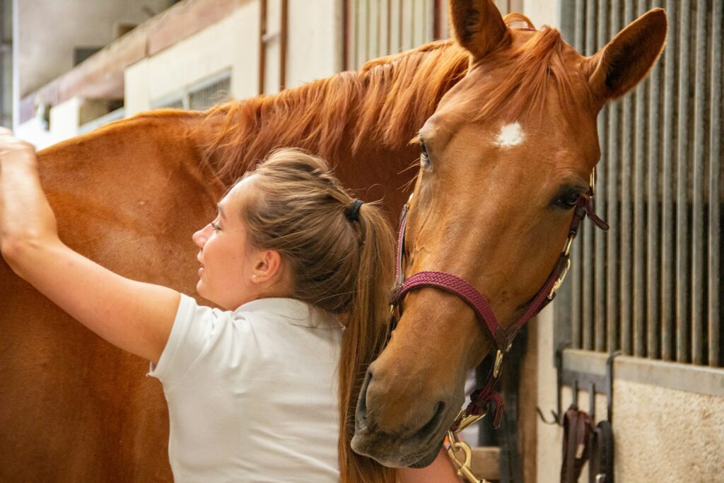 Woman in white crew neck t-shirt standing beside brown horse