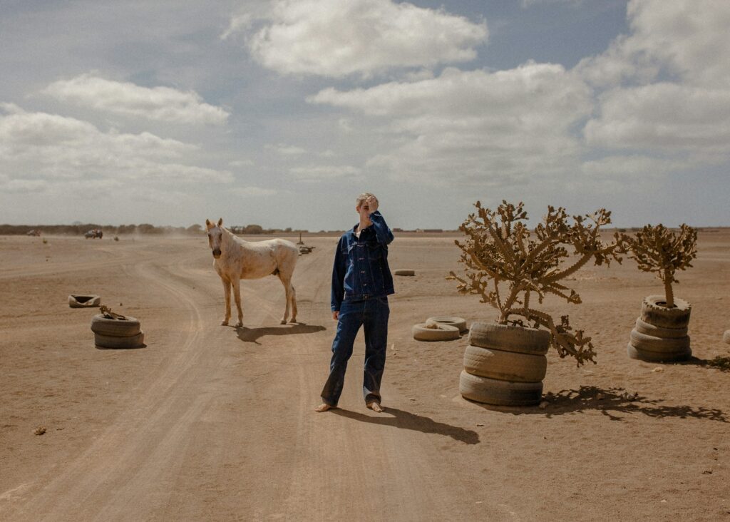 Man standing beside horse and plants