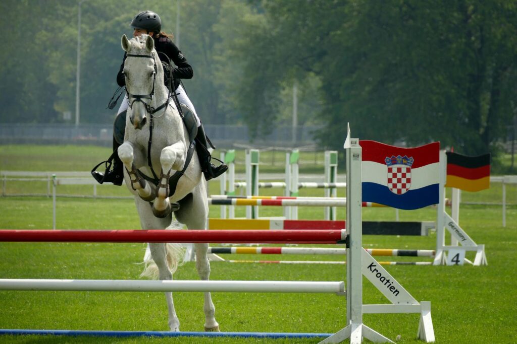 A rider on a white horse jumps hurdles at an equestrian event in Zagreb, Croatia.