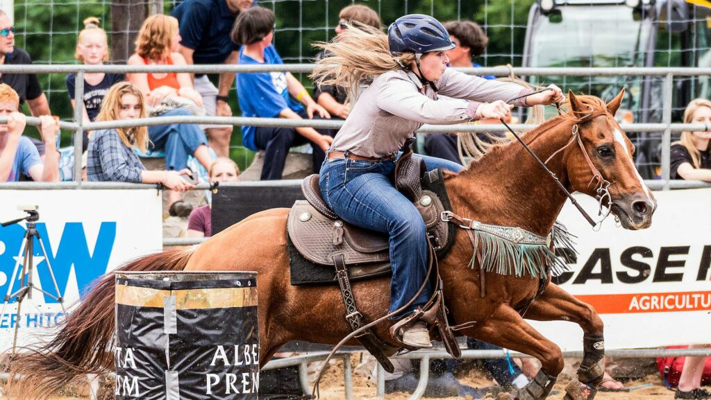 a woman in motion performing horseback riding.