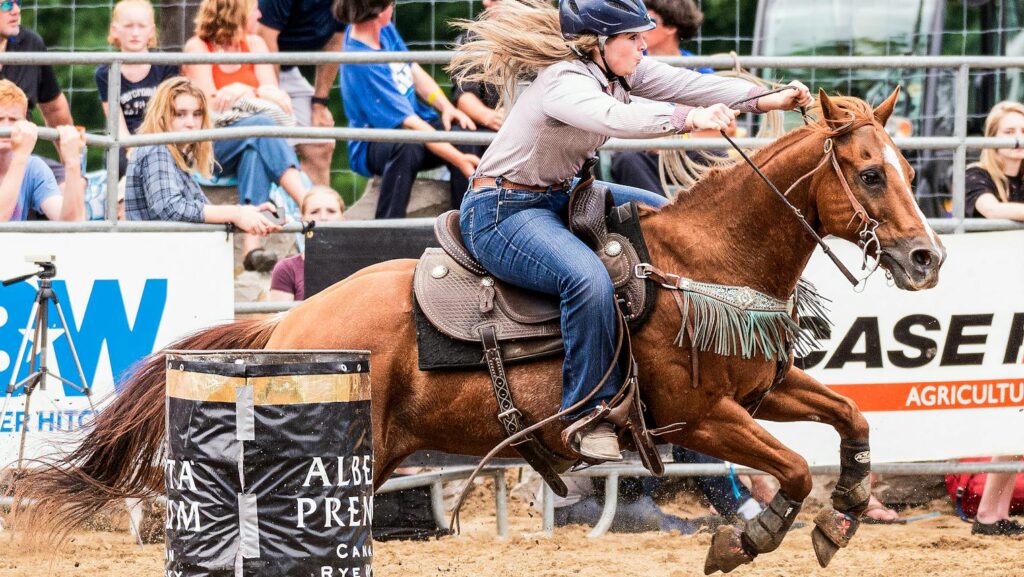 Action-packed rodeo event featuring a woman in motion performing horseback riding.