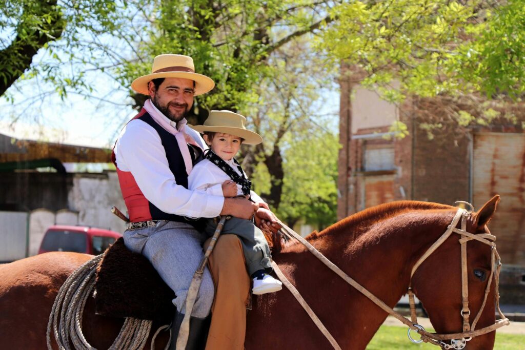 Faher and son in traditional attire enjoying a horseback ride