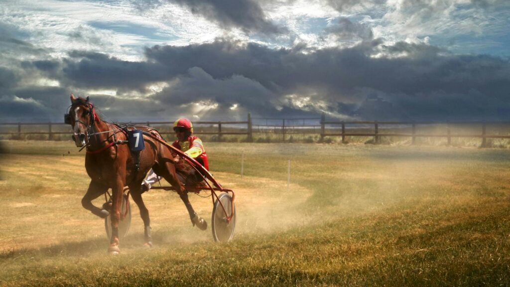 Dramatic scene of harness racing in Genêts, Normandie, France, capturing speed and energy.