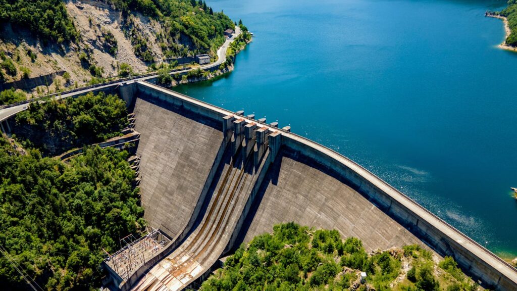 A stunning aerial view of Vacha Dam surrounded by lush greenery and blue waters in Bulgaria.