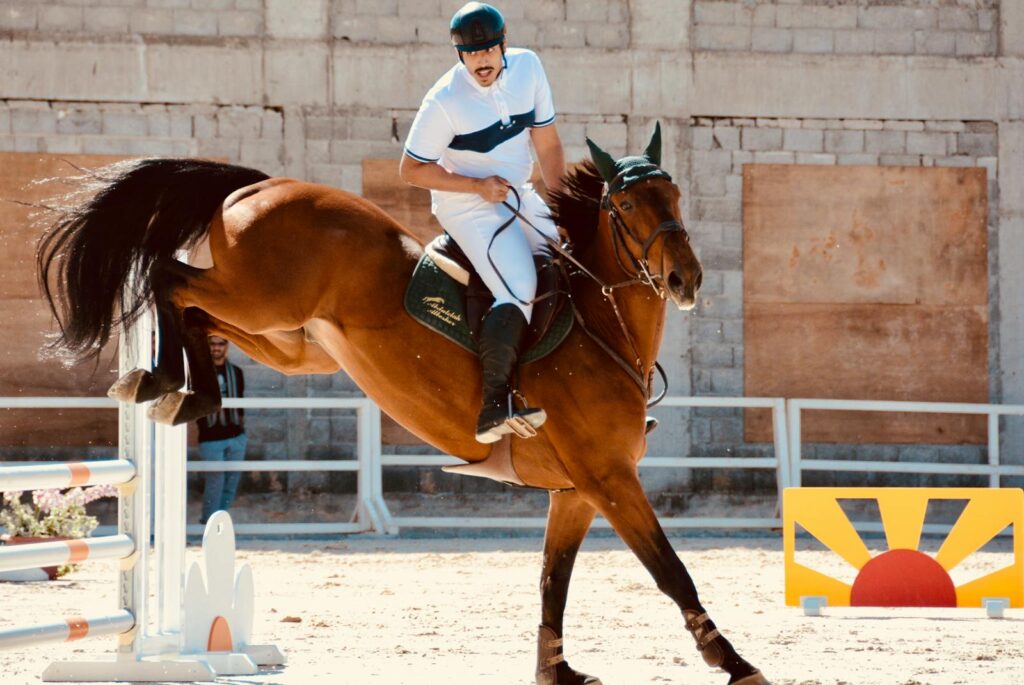 A thrilling equestrian show jumping competition featuring a skilled rider and horse in Riyadh, Saudi Arabia.