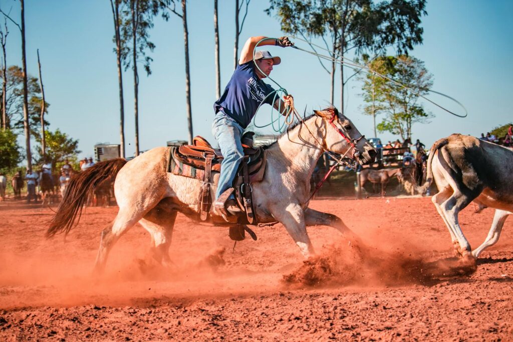 Cowboy roping cattle at a rodeo in Umuarama, Brazil, showcasing skill and tradition.