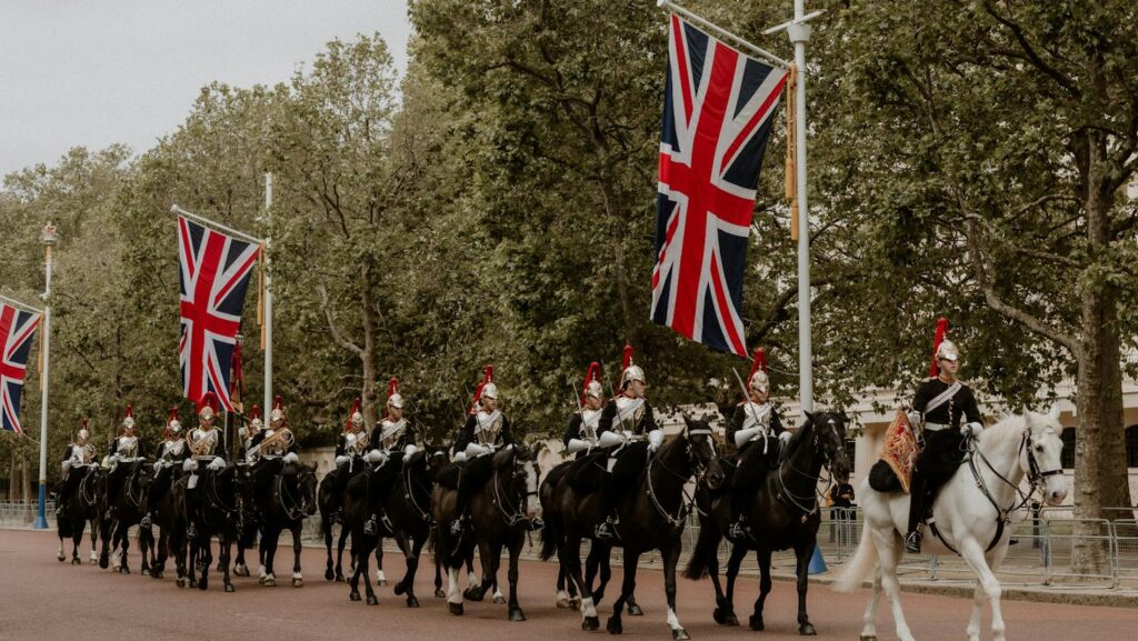 Ceremonial cavalry with Union Flags in a historical parade on The Mall, London.