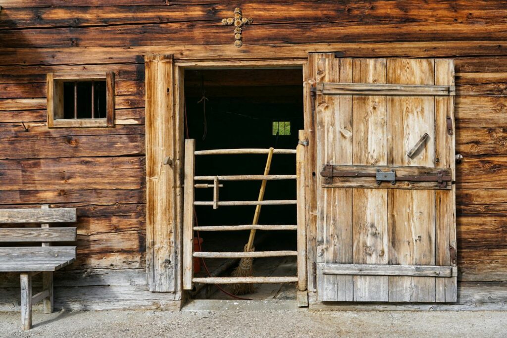 Rustic wooden barn door opening to a stable interior