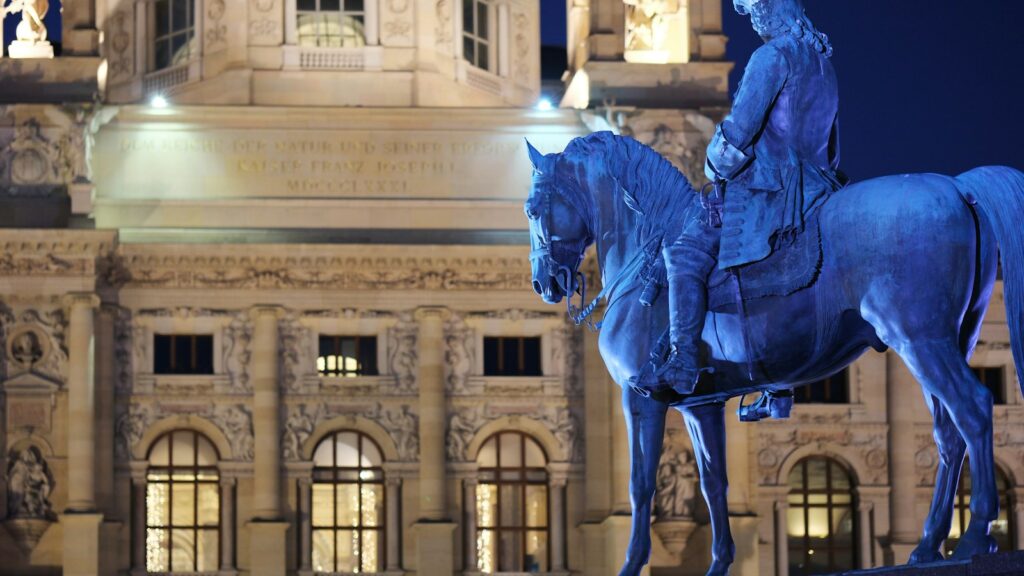 A statue of a man on a horse in front of a building
