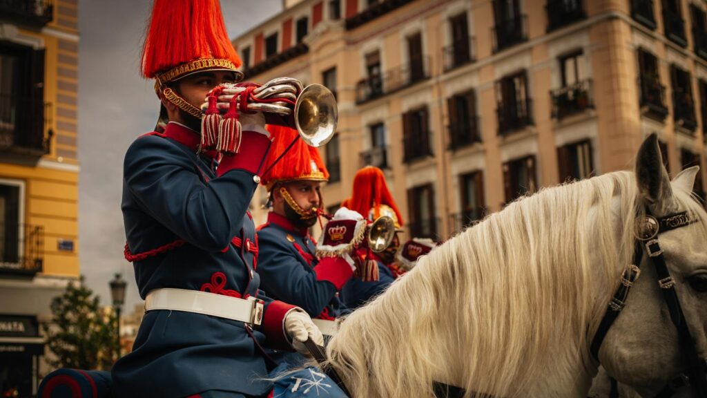 Spanish Royal Guard in uniform playing trumpets during a parade. Urban setting.