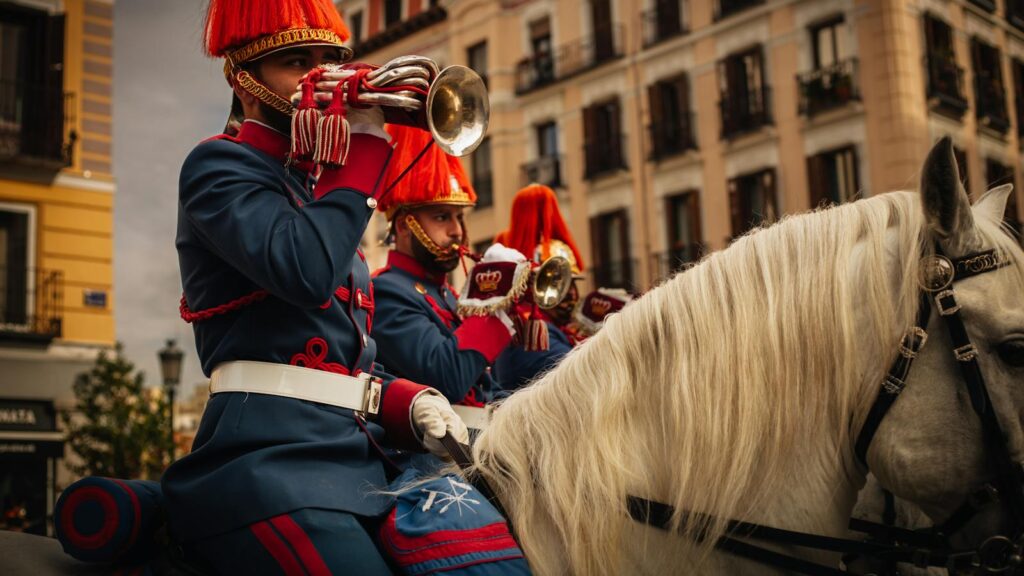 Spanish Royal Guard in uniform playing trumpets during a parade. Urban setting.