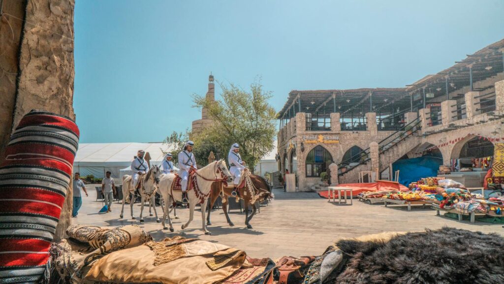 Vibrant marketplace in Doha with traditional textiles and riders on horses. Captures Qatari culture.