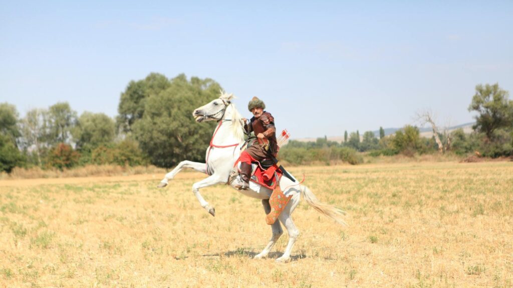 Man in period costume riding rearing horse