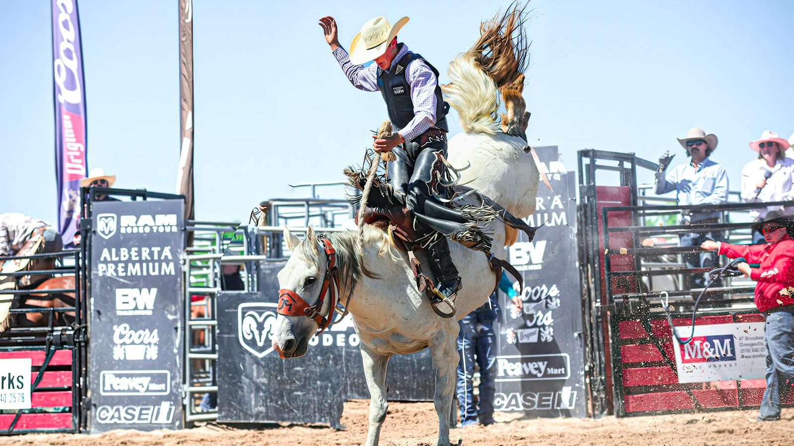 Dynamic image of a cowboy expertly riding a bucking bronco during a rodeo competition.