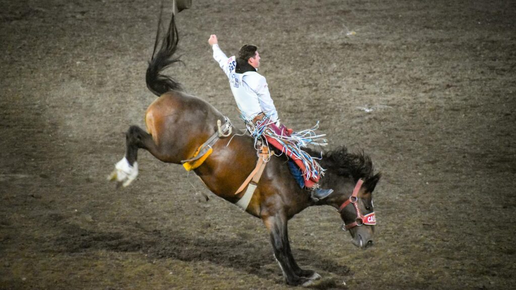 A thrilling moment captured at the Ellensburg Rodeo with a cowboy riding a bucking bronco.