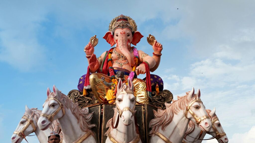 Vibrant Ganpati statue on a chariot in Mumbai during a festival procession.