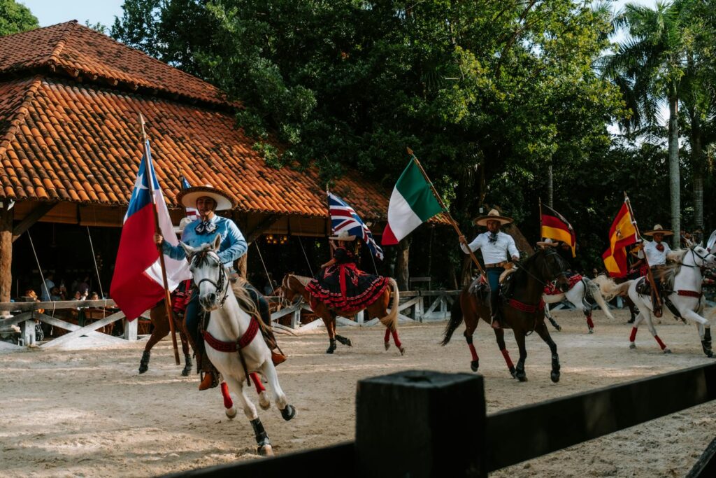 Vibrant equestrian show in Cancun featuring riders with international flags in traditional attire.