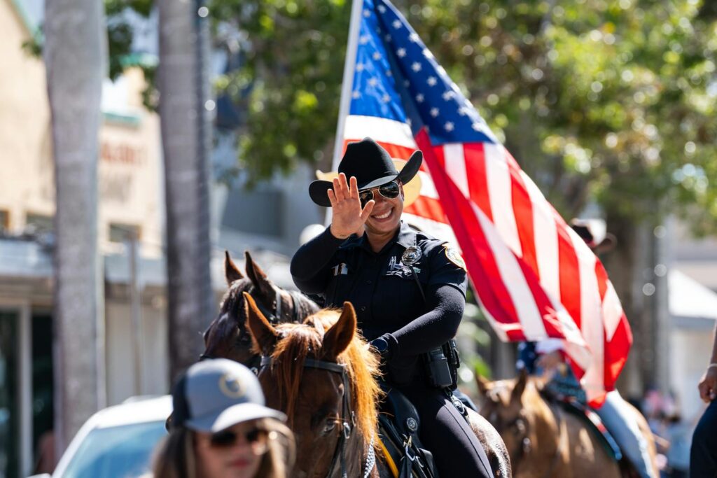 Smiling police officer on horseback during patriotic parade