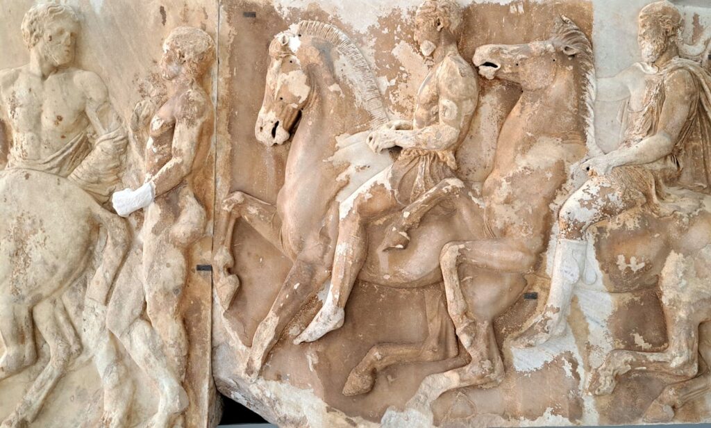 Ancient Greek marble relief depicting riders and horses