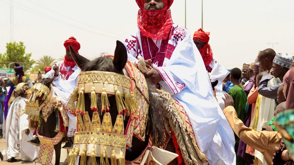 Colorful Durbar festival in Bauchi, Nigeria with riders in traditional attire on decorated horses.