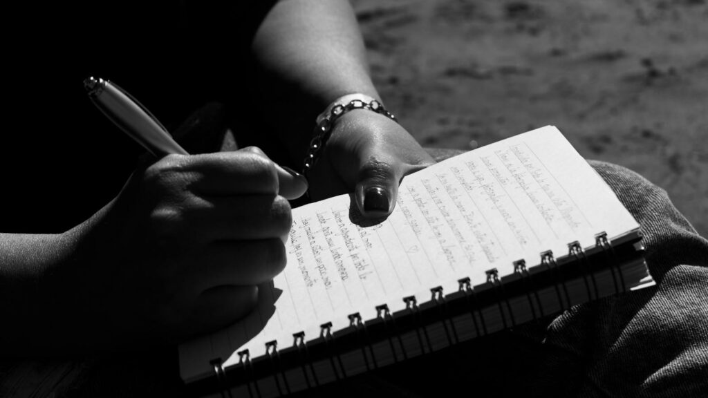 Close-up of a person writing in a notebook, captured in Mar del Plata, Argentina.