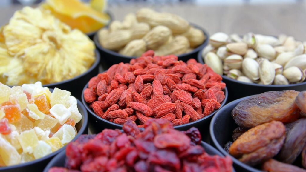 A vibrant collection of dried fruits and nuts in bowls, ideal for nutrition and healthy eating concepts.