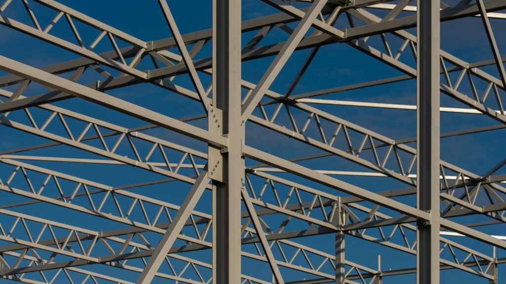 Detailed view of a steel framework structure against a blue sky, showcasing modern construction elements.