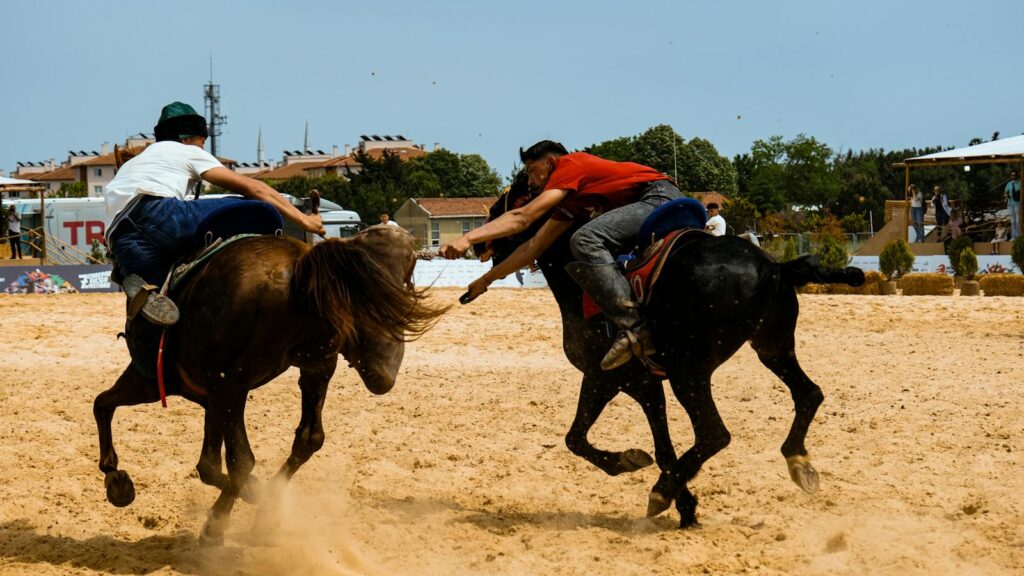 Intense equestrian contest featuring riders in action on sandy outdoor arena.