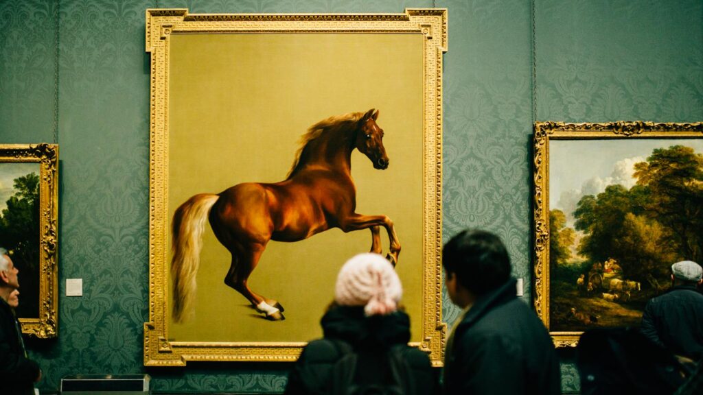 Visitors view a majestic horse painting at a museum, showcasing art appreciation and cultural exploration.
