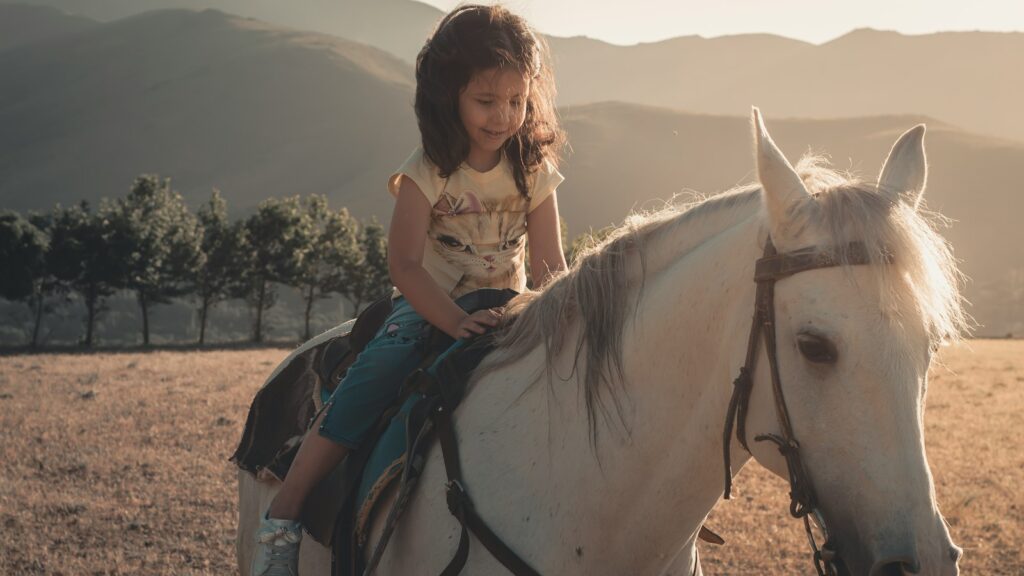 woman in white shirt riding white horse during daytime