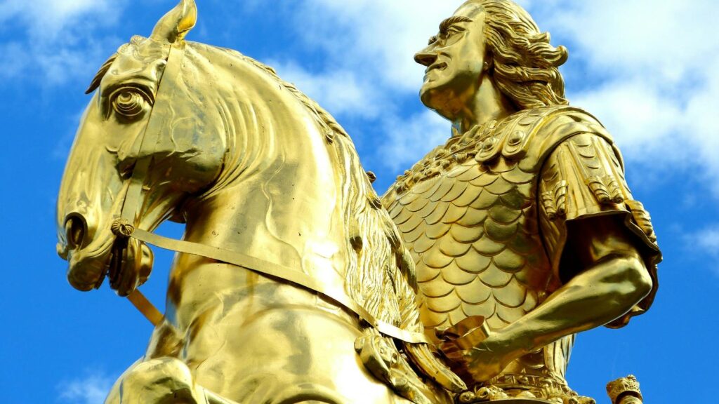 Close-up of the Golden Rider statue in Dresden with vibrant blue sky.