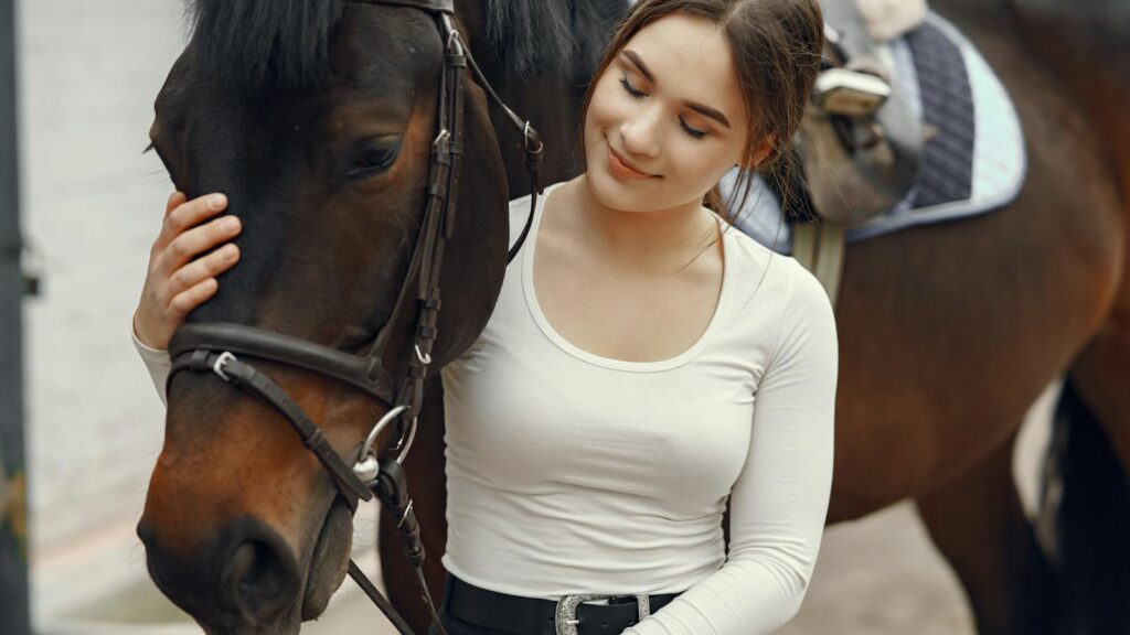 Young woman tenderly petting a horse, showcasing a bond between animal and human.