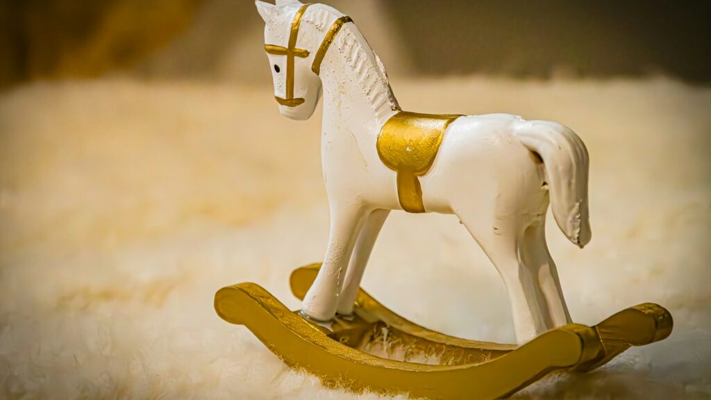 a toy rocking horse sitting on top of a white blanket