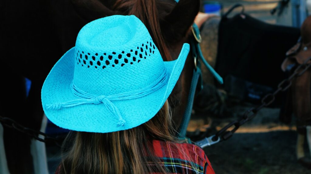 woman wearing blue cowboy hat