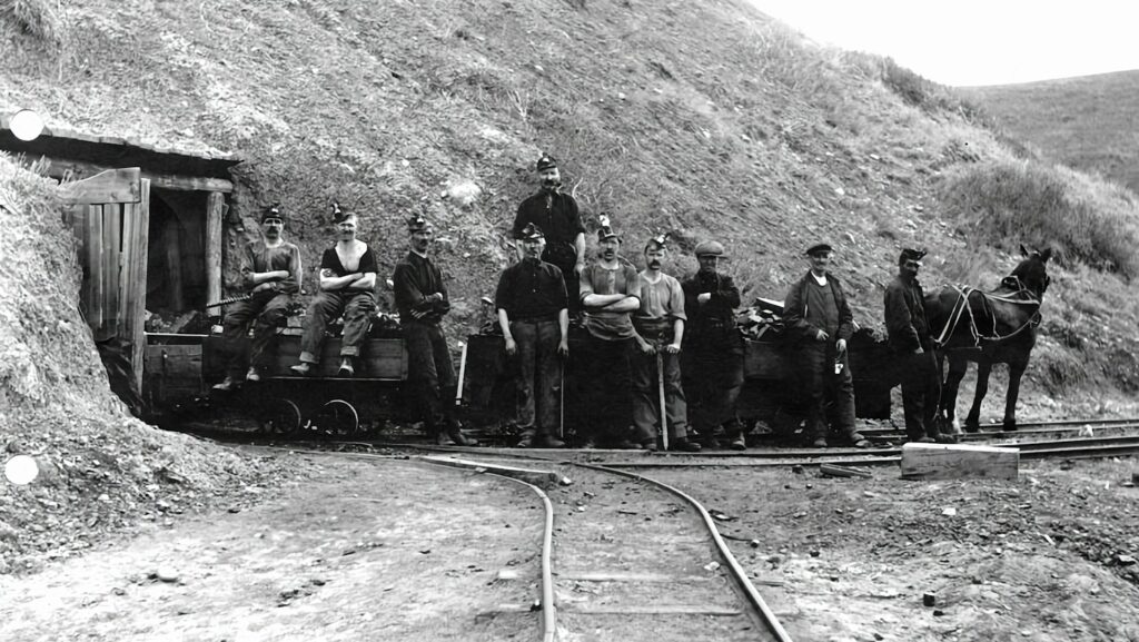 a group of men standing next to a train on a track