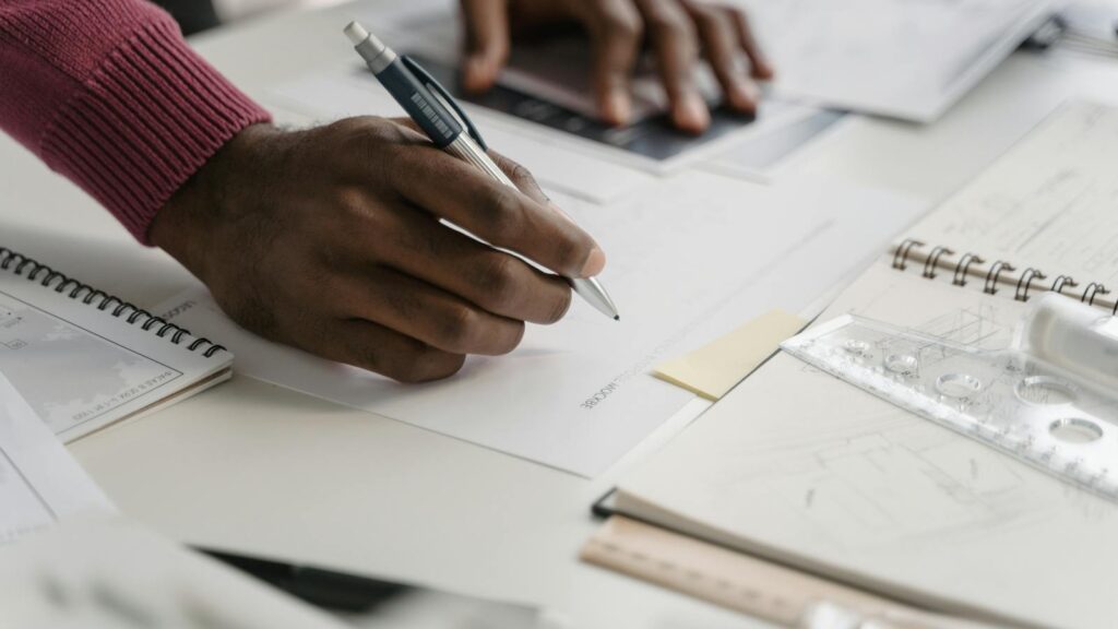 architect drafting on blueprints in a modern office environment.