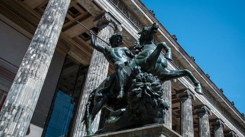 Low angle of a bronze horse and rider statue at the Altes Museum, Berlin on a sunny day.